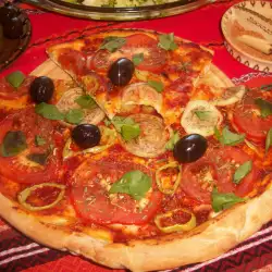 Pizza vegetariana con tomate, aceitunas y albahaca