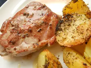 Aguja de cerdo a la sartén con patatas al horno