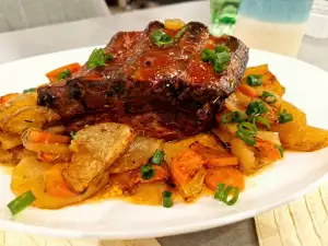 Costillas carnosas con guarnición de patatas y zanahorias