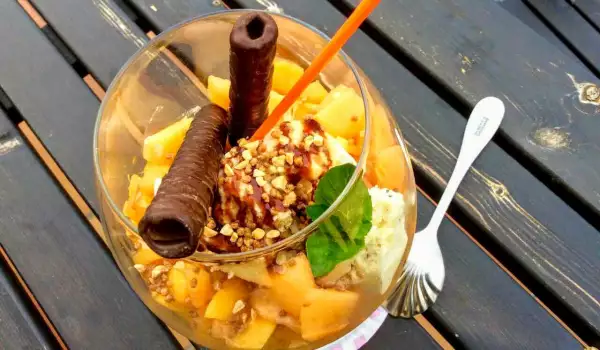 Postre de helado en copa con melocotones y albaricoques