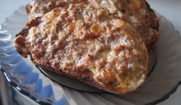Rebanadas de pan tostado con carne picada, huevo y queso