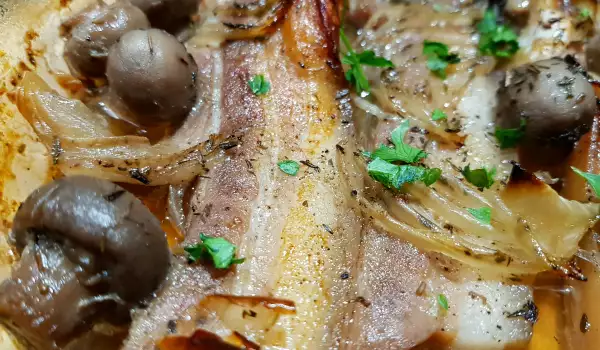 Panceta de cerdo al horno con cebolla y champiñones