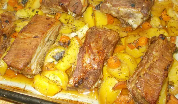 Costillas de cerdo con patatas y zanahorias al horno