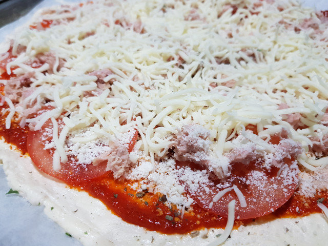 Pizza con atún, parmesano y tomate