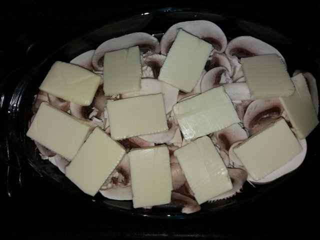 Filetes de cerdo con champiñones en una fuente de vidrio