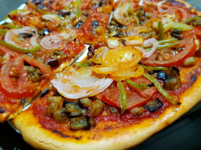 Pizza con berenjena, cebolla y tomate